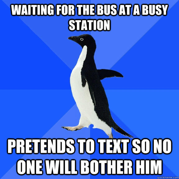 Waiting for the bus at a busy station pretends to text so no one will bother him  