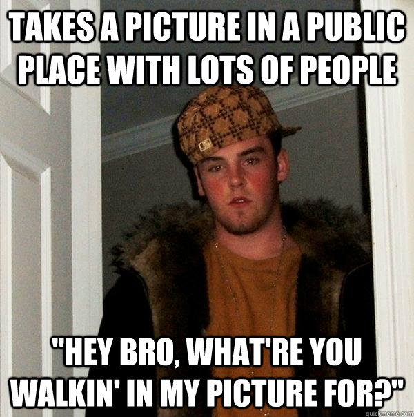 Takes a picture in a public place with lots of people 